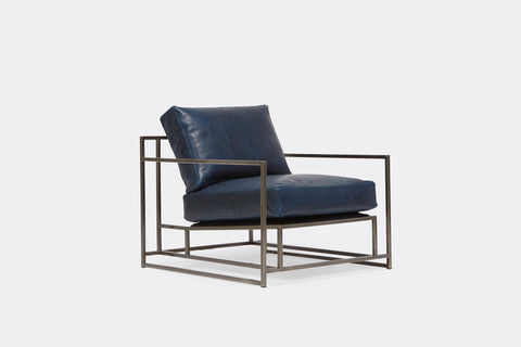 side of armchair with blue leather upholstery on antique nickel metal frame