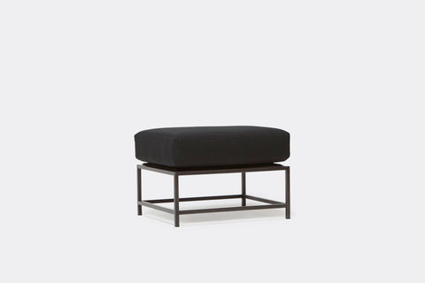 front of ottoman with black canvas upholstery on black metal frame