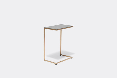 side of side table with black table top on antique brass metal frame
