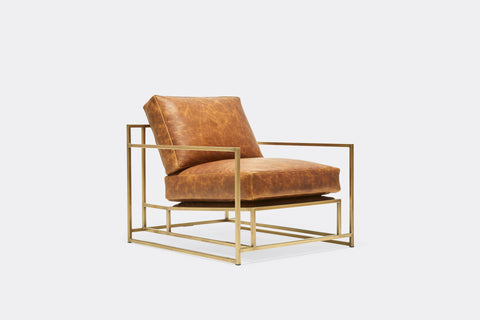 side of armchair with brown leather upholstery on antique brass metal frame