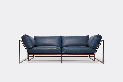 front of two seat sofa with blue leather upholstery and marble rust metal frame