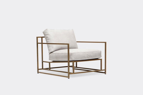 front of armchair with white leather upholstery on antique brass metal frame