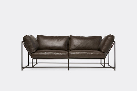 Front of two seat sofa with dark brown leather upholstery and black metal frame