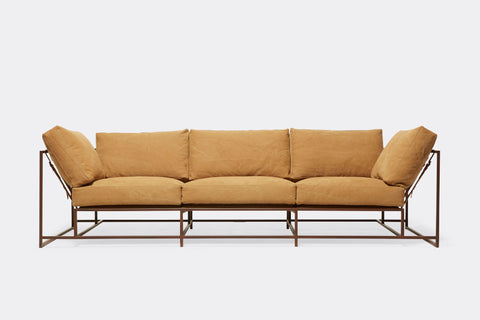front of sofa with tan canvas upholstery on marble rust metal frame