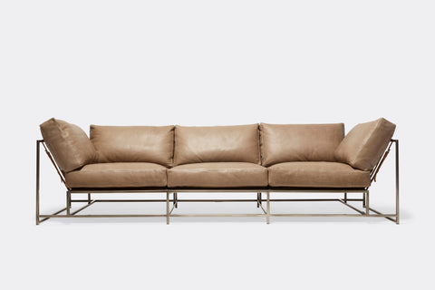 front of sofa with brown leather upholstery and brown leather belts on antique nickel metal frame