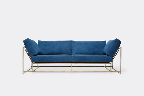Front of two seat sofa with blue canvas upholstery and antique brass metal frame