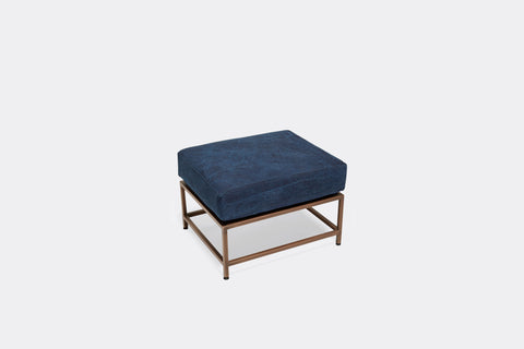 overhead of ottoman with blue canvas upholstery on antique copper metal frame