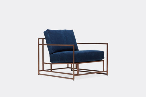 side of armchair with blue canvas upholstery and antique copper metal frame