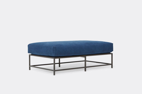 side of bench with blue canvas upholstery on black metal frame