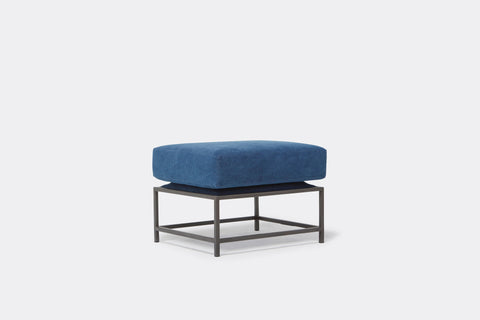 front of ottoman with blue canvas upholstery on black metal frame