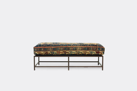 front of ottoman with antique rug upholstery on marbled rust metal frame