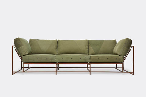 front of sofa with green canvas upholstery on marbled rust metal frame