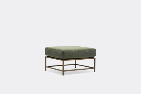 side of ottoman with green canvas upholstery on antique brass metal frame
