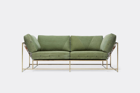 Front of two seat sofa with green canvas upholstery and antique brass metal frame