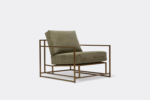 Front of armchair with green canvas upholstery on antique brass metal frame