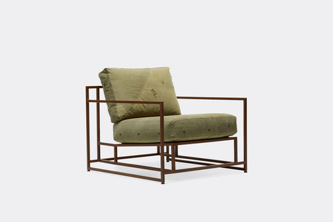 side of armchair with green canvas upholstery on marbled rust metal frame