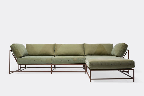 front of sectional with green canvas upholstery on marble rust metal frame