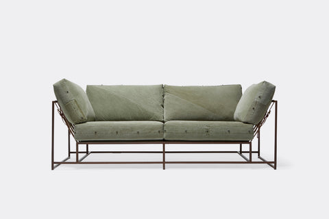 Front of two seat sofa with green canvas upholstery and marble rust metal frame