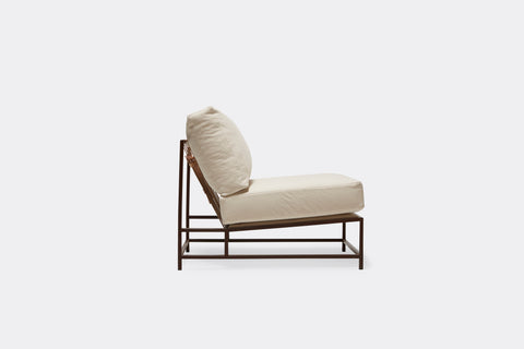 Sideview of lounge chair with cream canvas upholstery and marbled rust metal frame