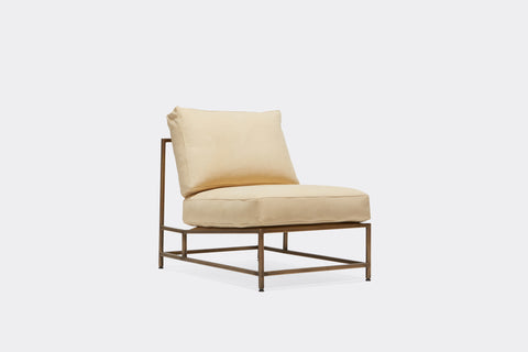 front of lounge chair with cream leather upholstery and antique brass metal frame