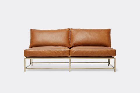 front of loveseat with brown leather upholstery on antique brass metal frame