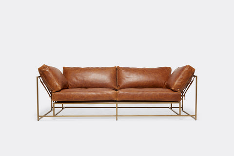 front of two seat sofa with brown leather upholstery and antique brass metal frame