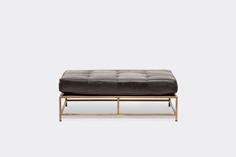 front of bench with black leather upholstery on antique brass metal frame