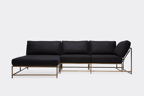 front of sectional with black wool upholstery on antique brass metal frame