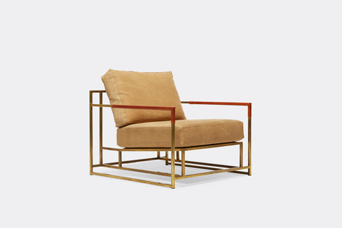 side of armchair with tan canvas upholstery on tarnished brass metal frame