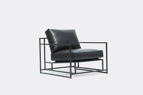 front of armchair with dark blue leather upholstery on blackened steel metal frame