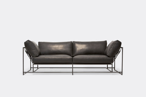 front of two seat sofa with black leather upholstery and black metal frame